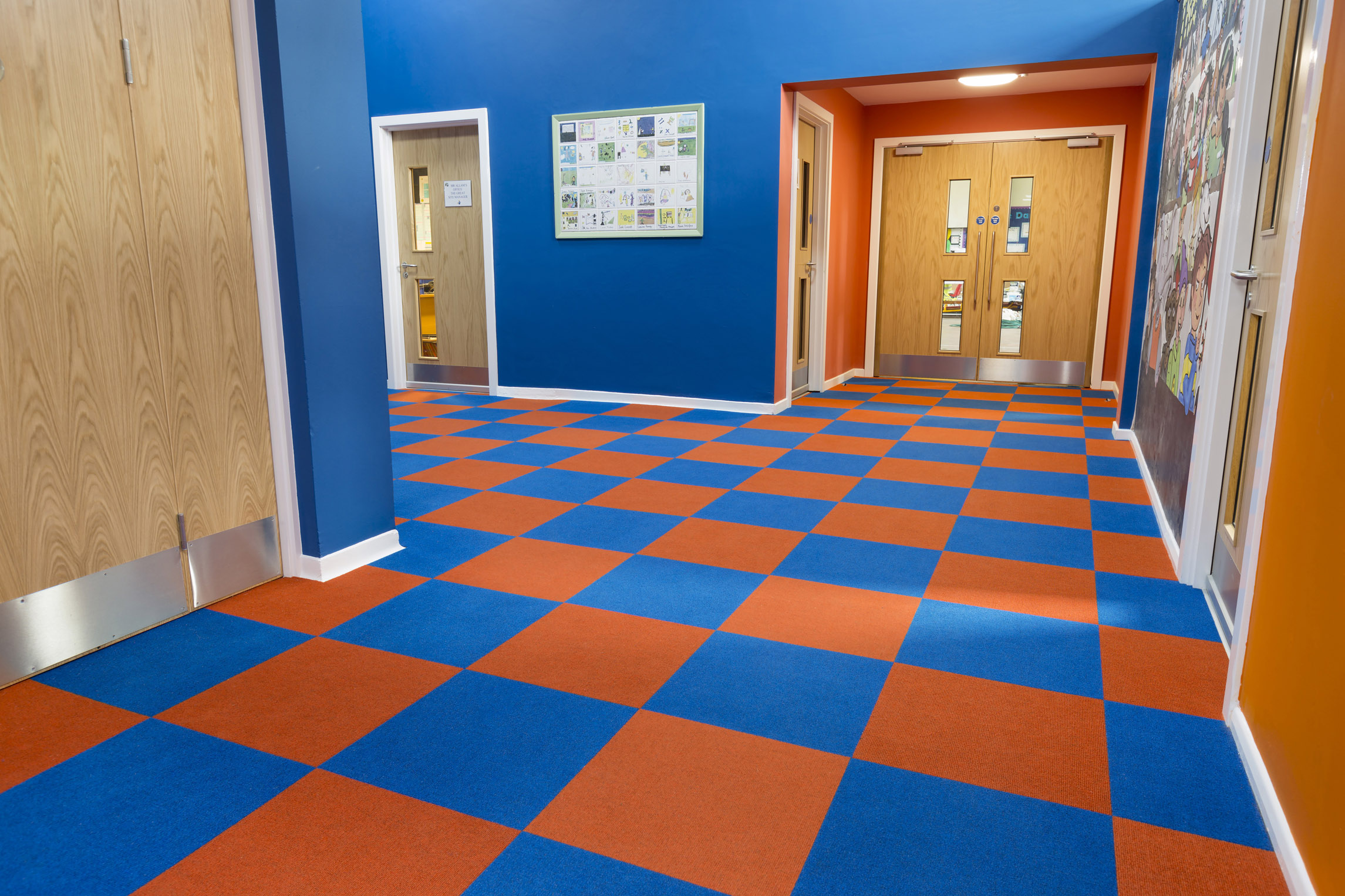 Heckmondwike Supacord Orange and Blue Carpet Tile in school hallway.